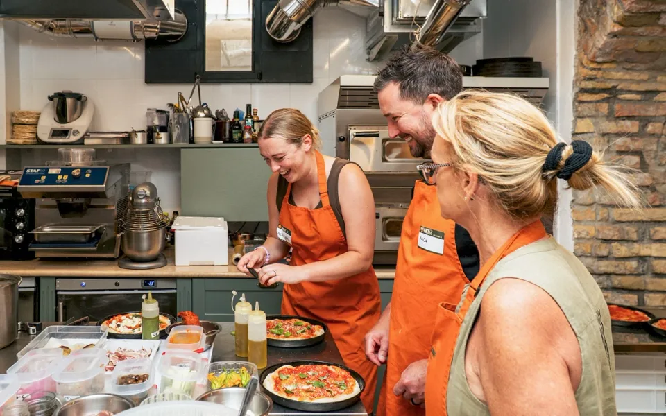 Ospiti che preparano l'impasto della pizza al banco della cucina