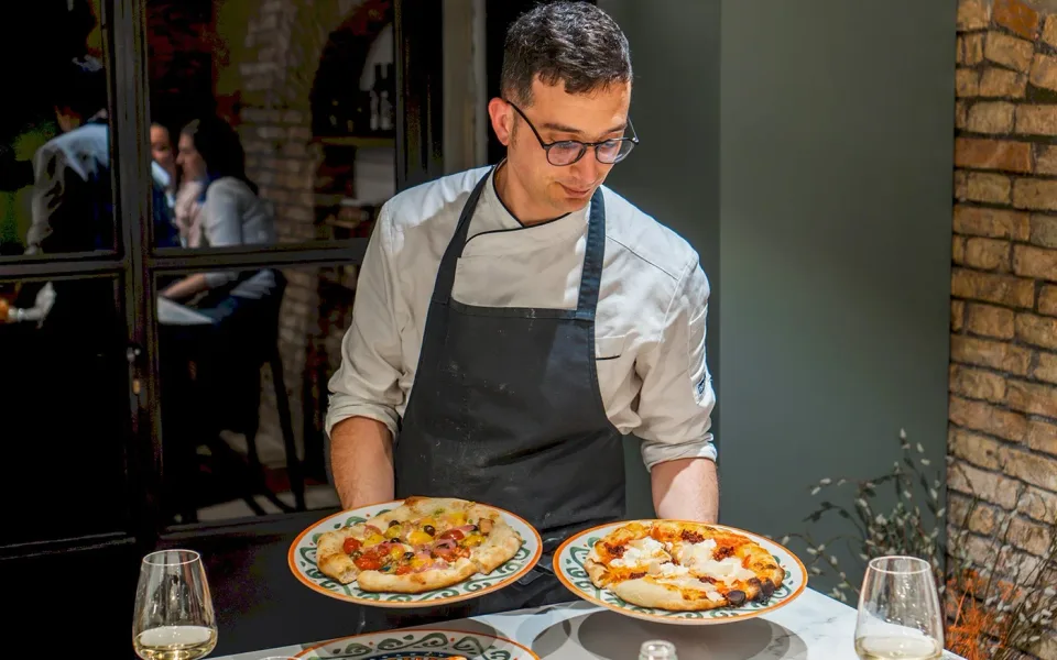 Un partecipante che presenta due pizze appena preparate