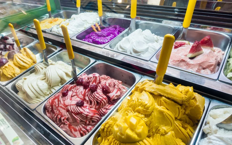 Eine farbenfrohe Auswahl an Gelato an einer Ladentheke