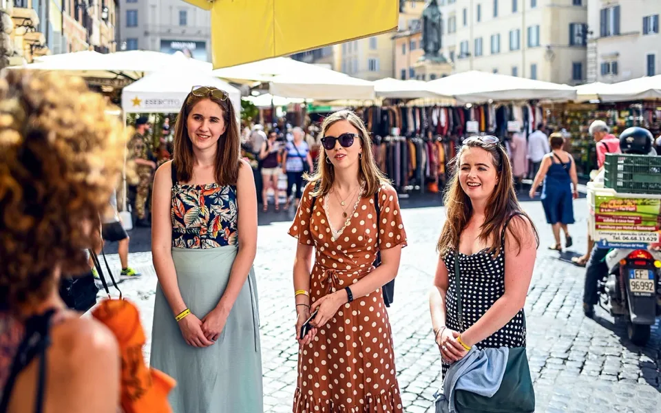 Gäste erkunden einen Lebensmittelmarkt im Freien in Rom