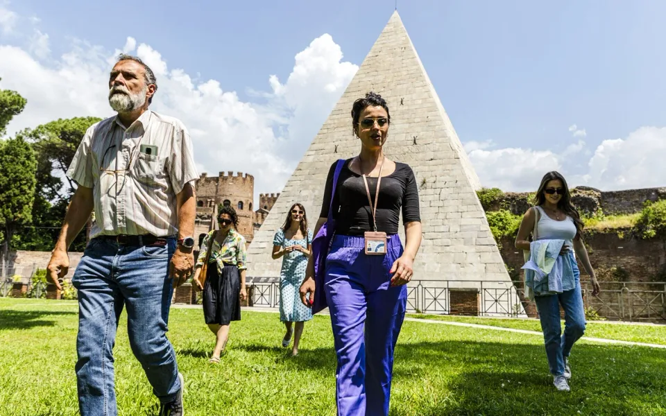 Participantes del tour gastronómico caminando cerca de la Pirámide de Cestius
