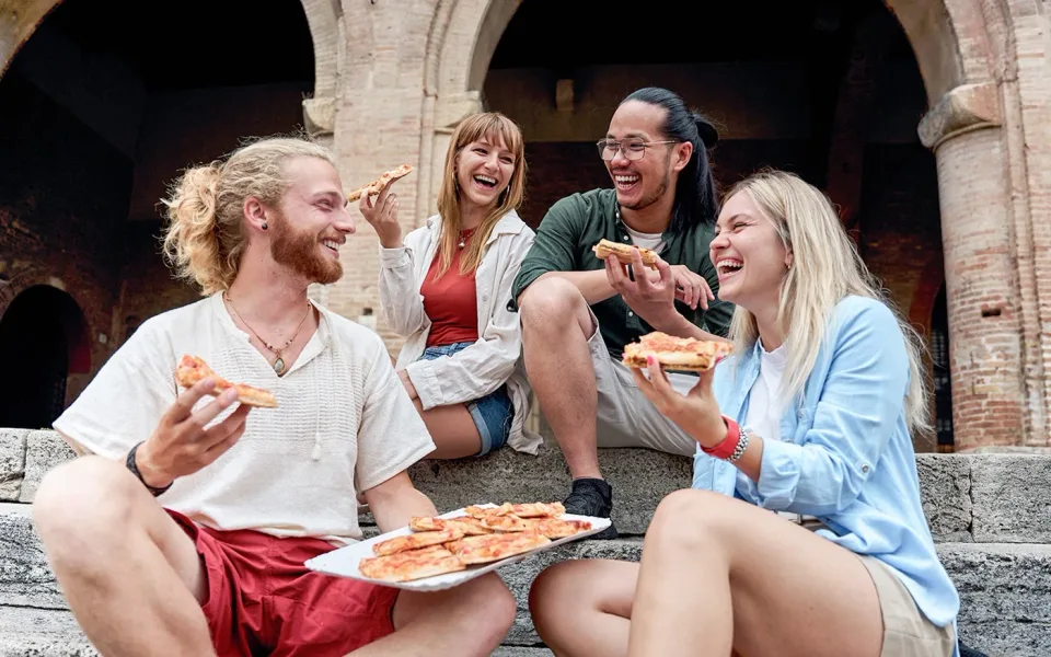 Gäste einer Food-Tour teilen Pizza in Trastevere