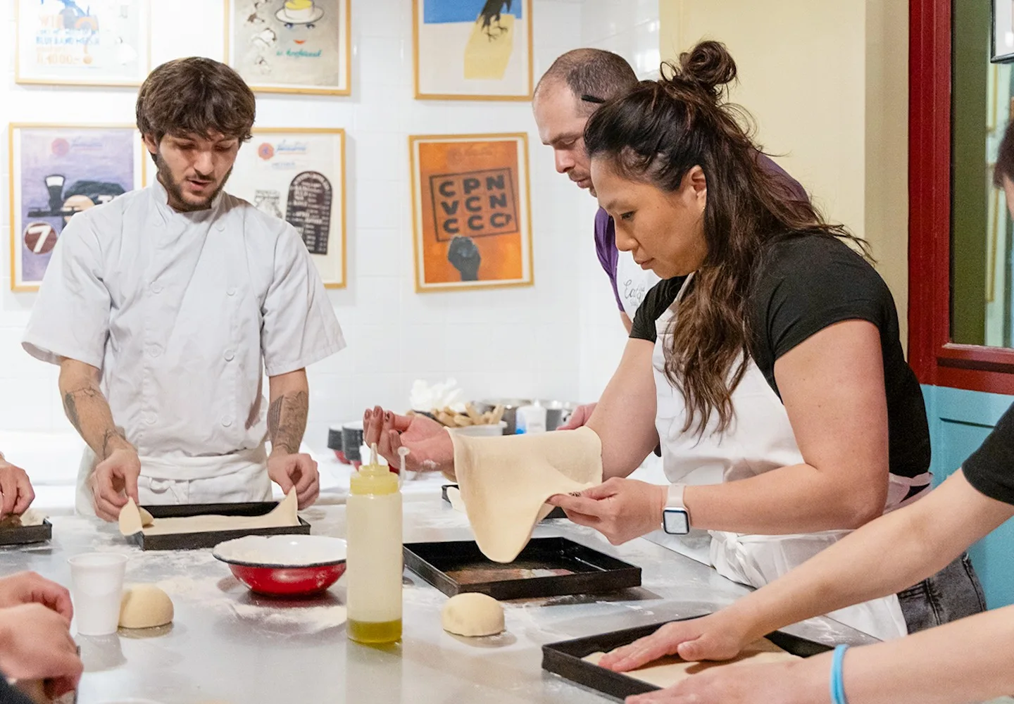 Participants cooking together in a Rome pizza class kitchen